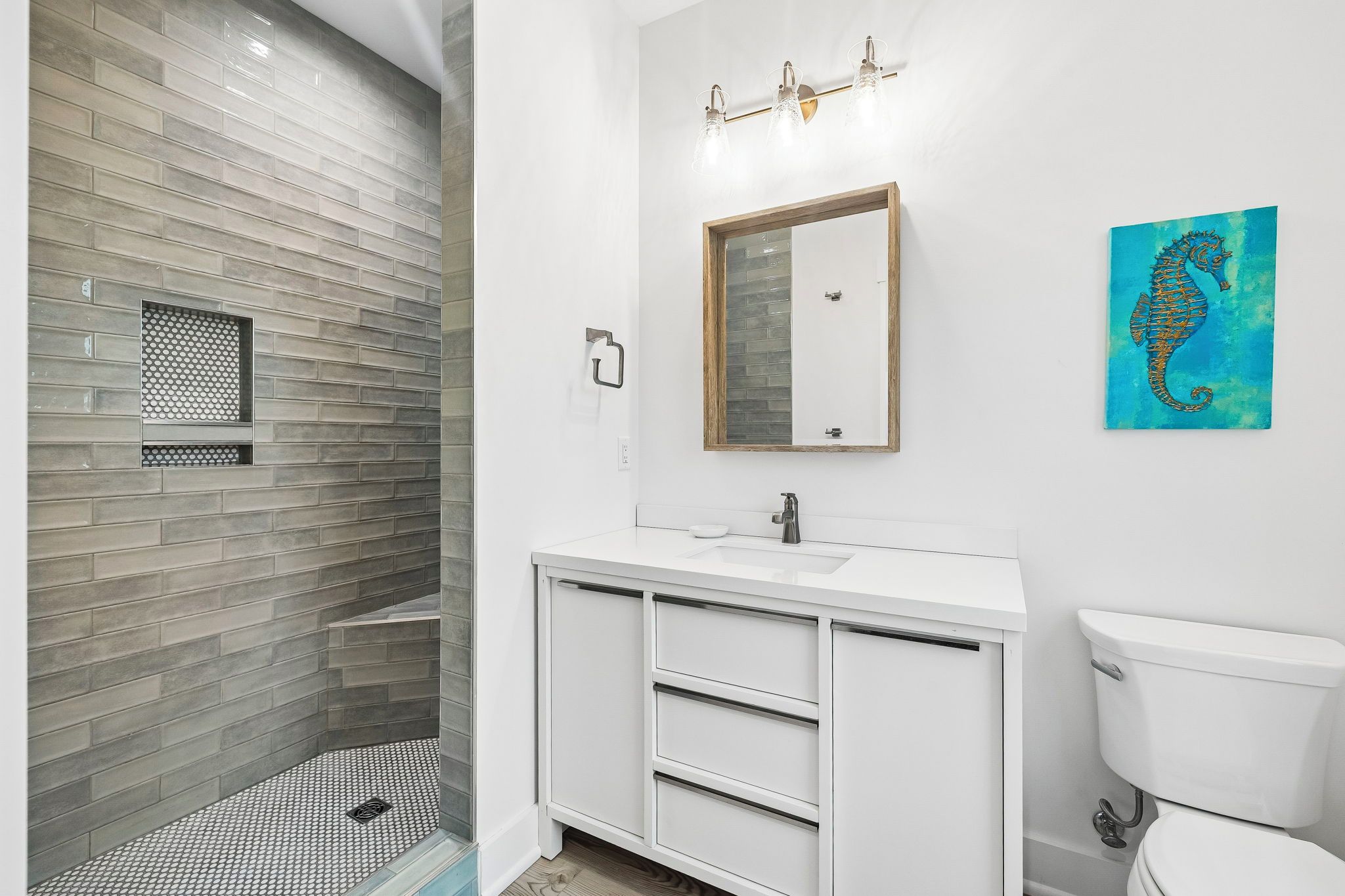 Refresh in your spa-inspired bathroom with a sleek walk-in shower, modern vanity, and coastal artwork that brings the beach to you.