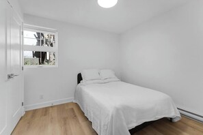 Ein Schlafzimmer mit einem Bett, einem Fenster und einer Tür.