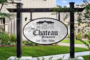 A sign for 'The Chateau Hemours' with a depiction of a house and the words 'Live · Dine · Relax' underneath. - Upscale Coastal Escape | King Suite & Fenced Yard (Port St. Joe)