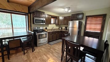 A kitchen with wooden cabinets, a stainless steel refrigerator, and a built-in oven.