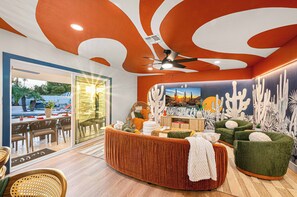 Ein modernes Interieur mit Deckenventilator, einer Rezeption und einer Wand mit Kaktus-Motiven.