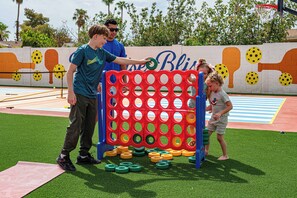 Ein Spielplatz mit einem volleyballnetz, einem roten und blauen Hindernisparcours und einer Wand mit Wandgemälde.