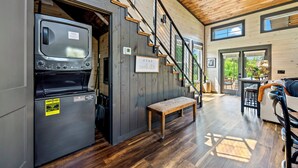 Un interior moderno con lavadora y secadora integradas, una escalera y un banco.