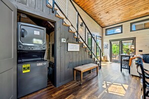Ein modernes Interieur mit eingebauter Waschmaschine und Trockner, einer Treppe und einer Sitzbank.