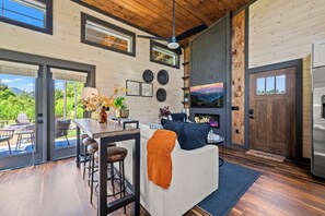 Eine moderne Küche mit Holzbalkendecke, einer Bar und einer Sitzecke mit Kamin.