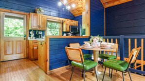 Una cucina compatta con mobili in legno, un forno a microonde e una finestra con vista su piante.