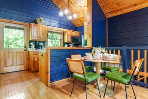 A compact kitchen with wooden cabinets, a microwave, and a window overlooking greenery. - Romantic Cabin w/ Hot Tub • 3mi to Pigeon Forge • King Bed • Fireplace (Pigeon For)