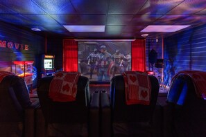 A movie theater with rows of seats, a screen, and a popcorn machine. - Romantic Cabin w/ Hot Tub • 3mi to Pigeon Forge • King Bed • Fireplace (Pigeon For)
