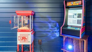 Un'atmosfera d'altri tempi in una sala giochi, con una macchina per i pop-corn e un gioco Pac-Man.