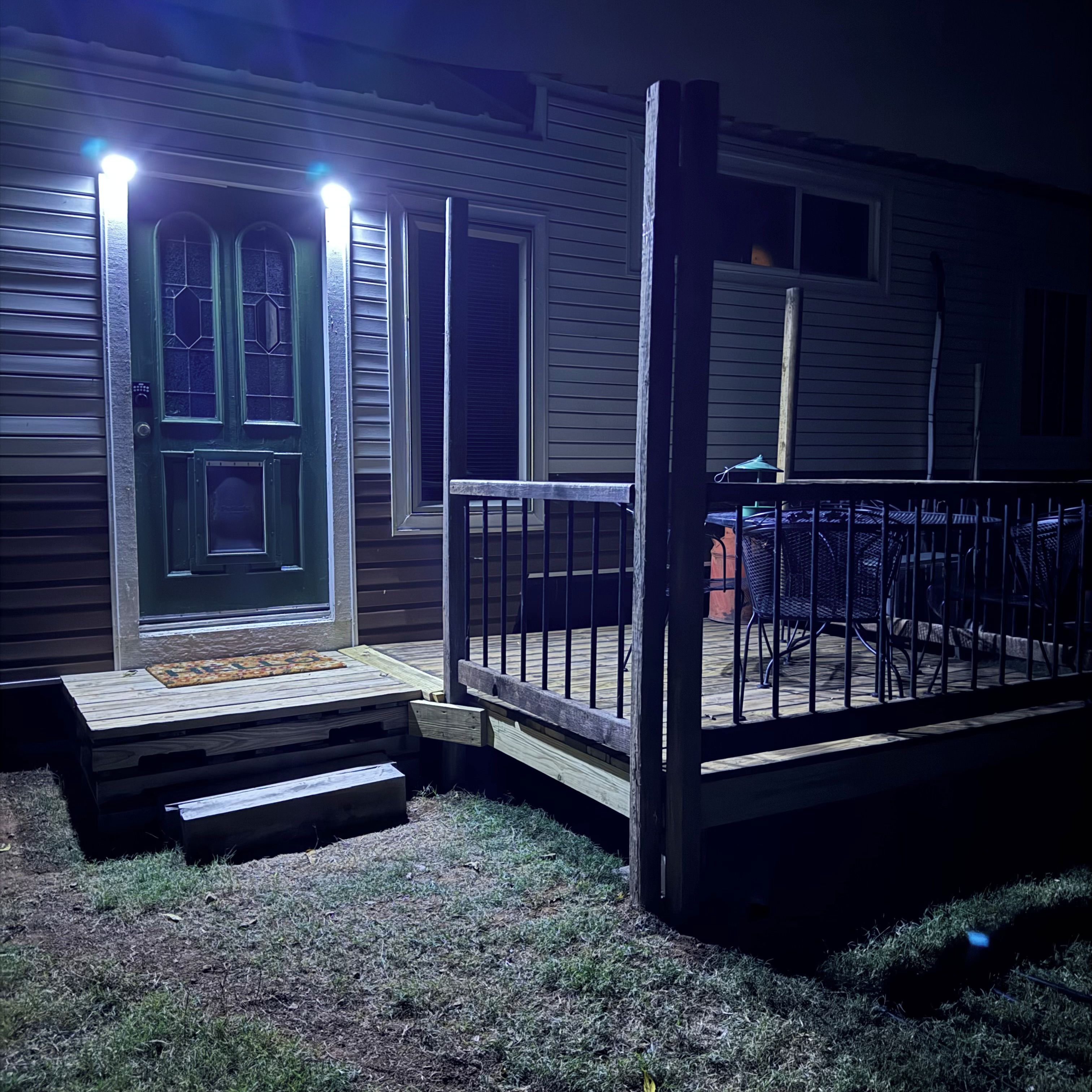 Ett hus med en ytterdörr, en liten veranda och en uteplats.