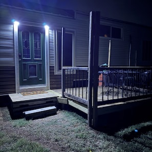 A house with a front door, a small porch, and a deck area.