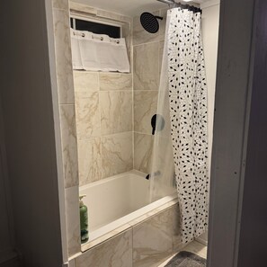 Kylpyhuone, jossa on suihku, kylpyamme ja wc.