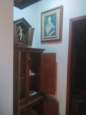Ein Zimmer mit einem Holzkasten, einem gerahmten Bild an der Wand und einer teilweise geöffneten Tür.