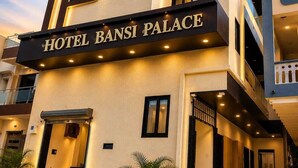 Un immeuble hôtelier à plusieurs étages, sur lequel on peut lire l’inscription « HÔTEL BANSI PALACE ».