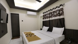 Une chambre d’hôtel équipée d’un lit, d’une table de chevet, d’un téléphone, d’un climatiseur et d’une porte.