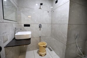 Un baño moderno con un lavamanos blanco, inodoro y ducha.