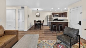 A modern apartment with a living room, dining area, and kitchen. - 2-B Grand County Redcliff Condo (Moab)