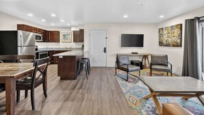 A modern kitchen with a central island, wooden cabinets, and a stainless steel refrigerator. - 2-B Grand County Redcliff Condo (Moab)