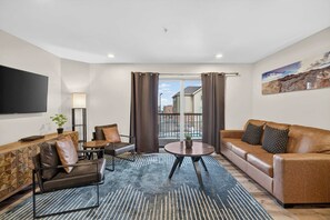 A modern living room with a sofa, armchair, and a coffee table. - 4-A Arches Redcliff Condo (Ground Floor) (Moab)