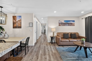 A modern interior with a dining area, a sofa, and a coffee table. - 4-B Slick Rock Redcliff Condo (Pool View) (Moab)