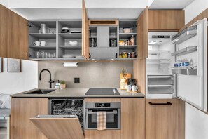A modern kitchen with built-in appliances, a dishwasher, and a coffee station. - Urban Escape Suite | Ocean View | Downtown (Miami)