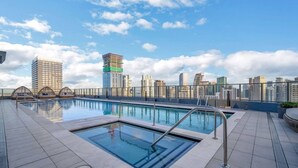 A rooftop swimming pool with a city skyline in the background. - Urban Escape Suite | Ocean View | Downtown (Miami)