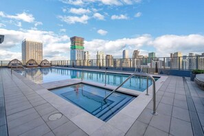 Ein Pool auf dem Dach mit einer Stadtkulisse im Hintergrund.