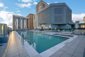 A modern building with a pool area, including a pool, lounge chairs, and a covered seating area. - Urban Escape Suite | Ocean View | Downtown (Miami)