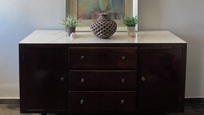 A dark wooden cabinet with three drawers, a decorative vase, and two potted plants on top. - Lovely 1-bedroom Rental Unit in Mazatlán Centro (Mazatlán)