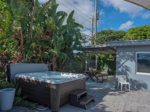 A hot tub in a garden with a wooden deck, a small table, and a chair. - 3BR 2BA house, Jacuzzi, Minutes to beach, in fabulous Fort Lauderdale with AC (Fort Lauderdale)