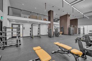 A gym with weightlifting equipment, benches, and cardio machines. - Brand New Building & Amazing Amenities (Miami)