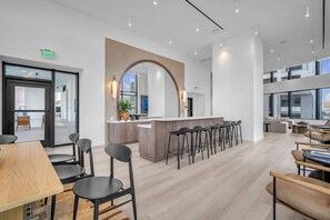 A modern interior with a bar area, seating, and a large mirror. - Brand New Building & Amazing Amenities (Miami)