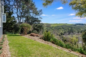 A landscaped garden with a lawn, a variety of shrubs, and trees.