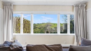 A room with a large window, a sofa, and curtains.
