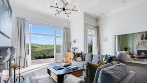 A spacious living room with a fireplace, a large sofa set, and a view of the outdoors.