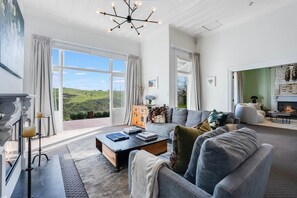 A spacious living room with a fireplace, a large sofa set, and a view of the outdoors.