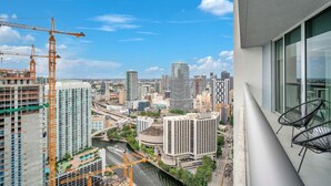 Un edificio alto con vista a un paisaje urbano, incluyendo grúas de construcción y diversos edificios.