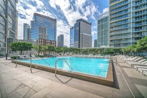 A rooftop pool with lounge chairs and a view of surrounding high-rise buildings. - The Enso Suite Luxury Brickell (Miami)
