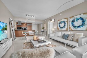 A modern living room with a sofa, coffee table, and a television. - The Enso Suite Luxury Brickell (Miami)