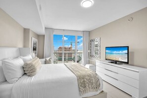 Ein modernes Hotelzimmer mit einem großen Bett, einem Fernseher und Blick auf eine Baustelle.
