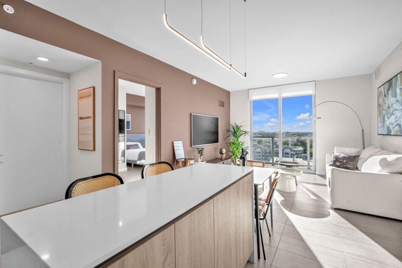 A modern living space with a central island dining table, a sofa, and a television.