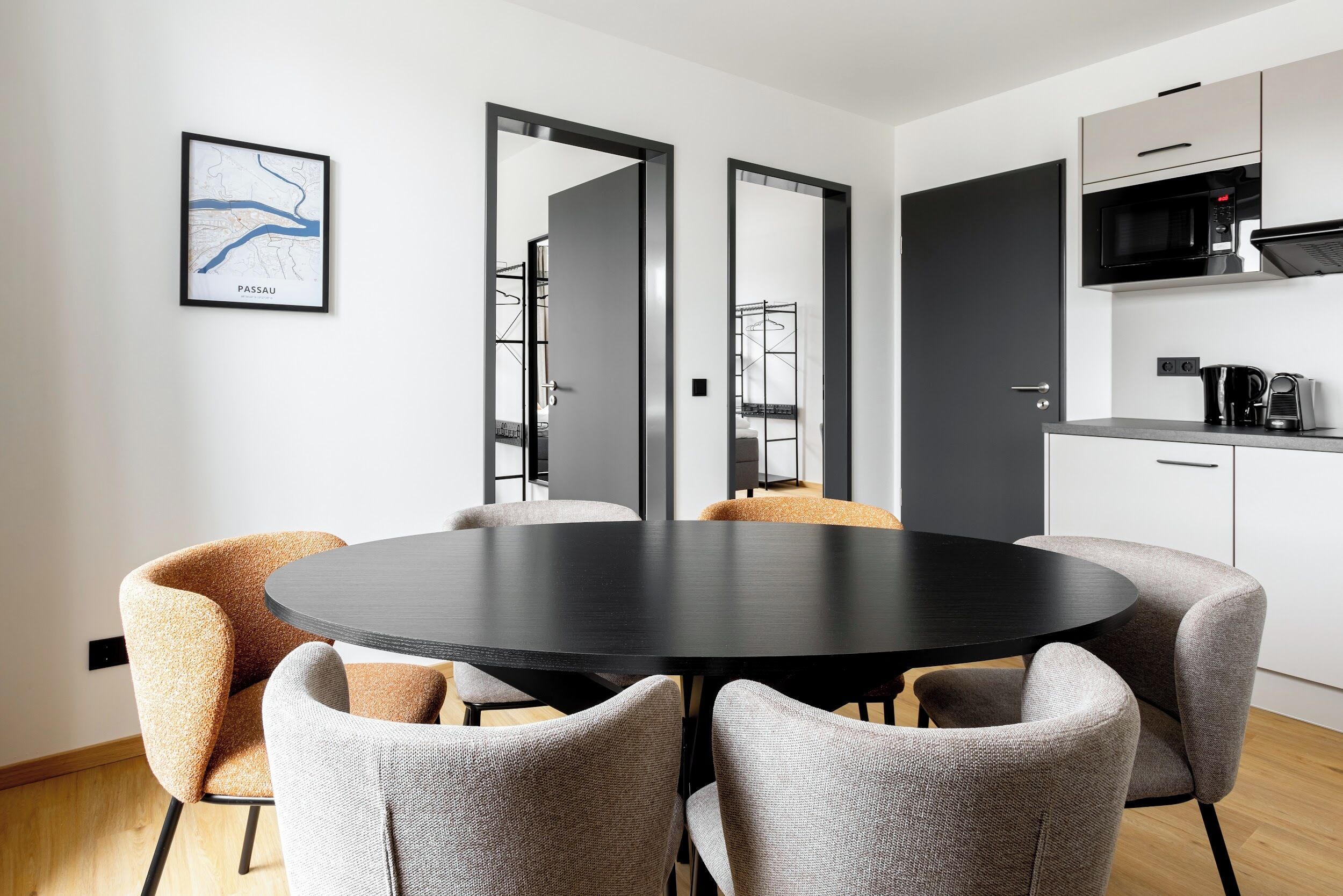 A modern kitchen with a black countertop, white cabinets, and a microwave.
