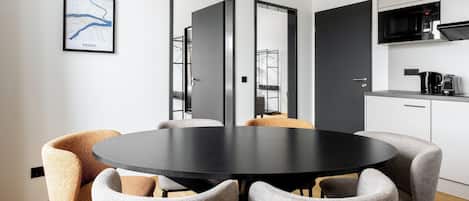 A modern kitchen with a black countertop, white cabinets, and a microwave.