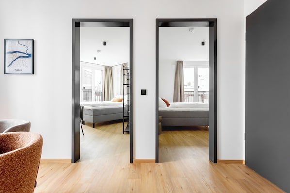 Habitación de hotel con cama, una silla y vistas a la ciudad a través de una ventana.