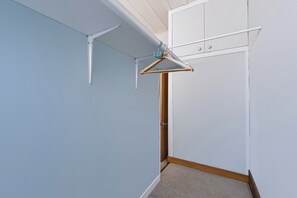 A corner of a room with a white door, a wooden floor, and a white wall. - Hannan House - Whitianga Holiday Home (Whitianga)