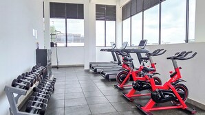A gym with exercise equipment, including treadmills and stationary bikes, and a weight rack. - One Bedroom in Westlands close to GTC, JW Mariott,Sarit Centre,Aga Khan Hospital (Nairobi)