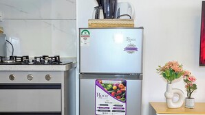 A kitchen with a stainless steel refrigerator, a gas stove, and a white cabinet. - One Bedroom in Westlands close to GTC, JW Mariott,Sarit Centre,Aga Khan Hospital (Nairobi)