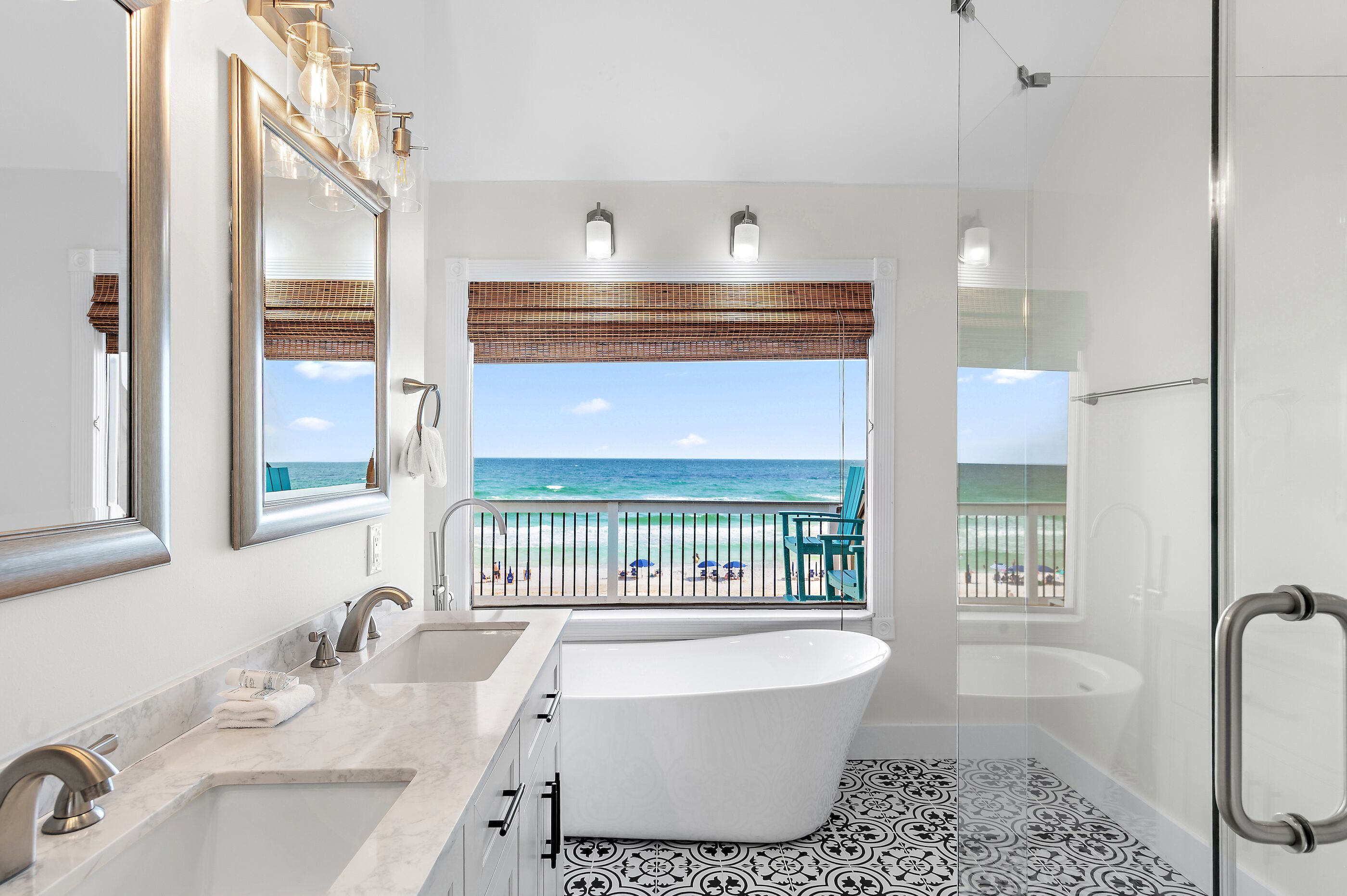 Une salle de bain moderne dotée d’une grande baignoire, d’une douche et offrant une vue sur la plage.