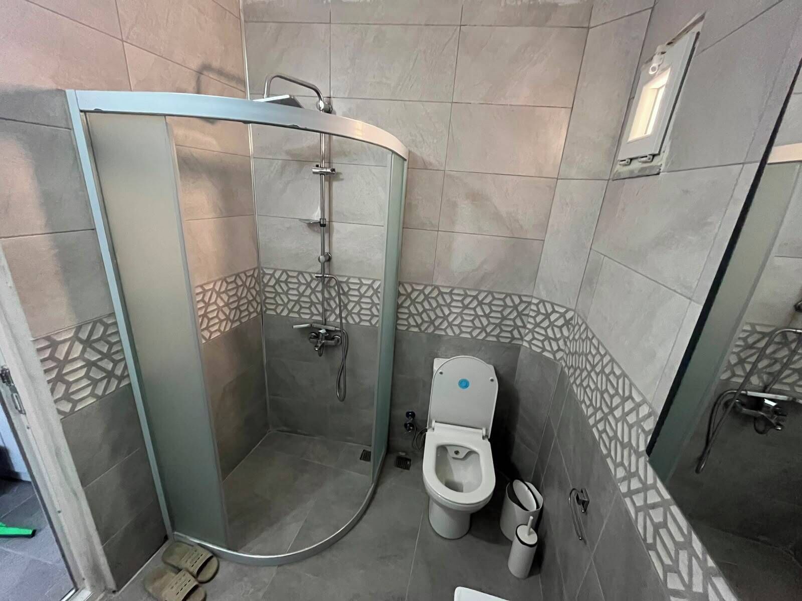 Une salle de bain avec une douche à parois de verre, des toilettes et un bidet.