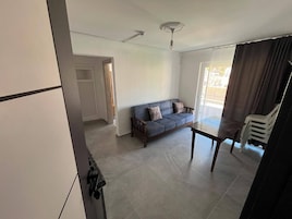 A living room with a sofa, a table, and a ceiling fan.